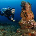 Diver next to statue at Coral Garden dive site in Tulamben, Bali